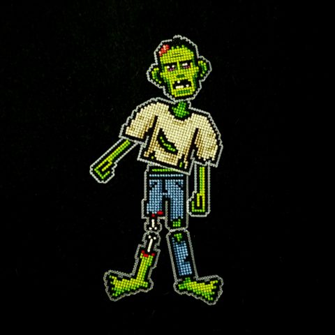 zombie cross stitch embroidery hanging decoration on a black background